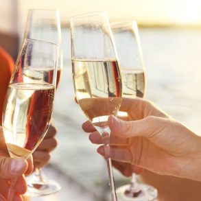 Happy friends with glasses of champagne on maui dinner cruise