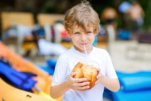 Young boy sipping from a coconut and enjoying the things to do on Maui with kids