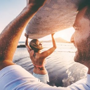 Happy couple surfing on Maui in December