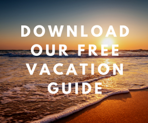 Sunset over ocean with overlaying text of download our free Vacation Guide