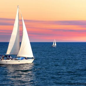 Sailboat sailing towards sunset on a calm evening | Catamaran tours on Maui