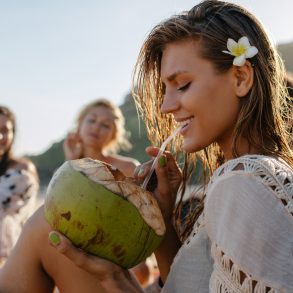 Girl sipping a coconut on Hawaiian Beach | Things to Do on Maui Off the Beaten Path