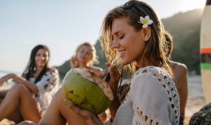 Girl sipping a coconut on Hawaiian Beach | Things to Do on Maui Off the Beaten Path