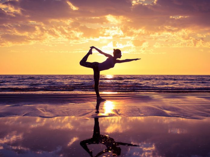 Woman enjoying a Maui yoga retreat on the beachga