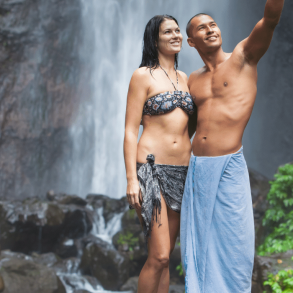 Couple standing in front of waterfall smiling