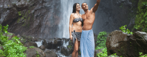 Couple standing in front of waterfall smiling