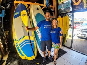 Store owners in front of paddleboards