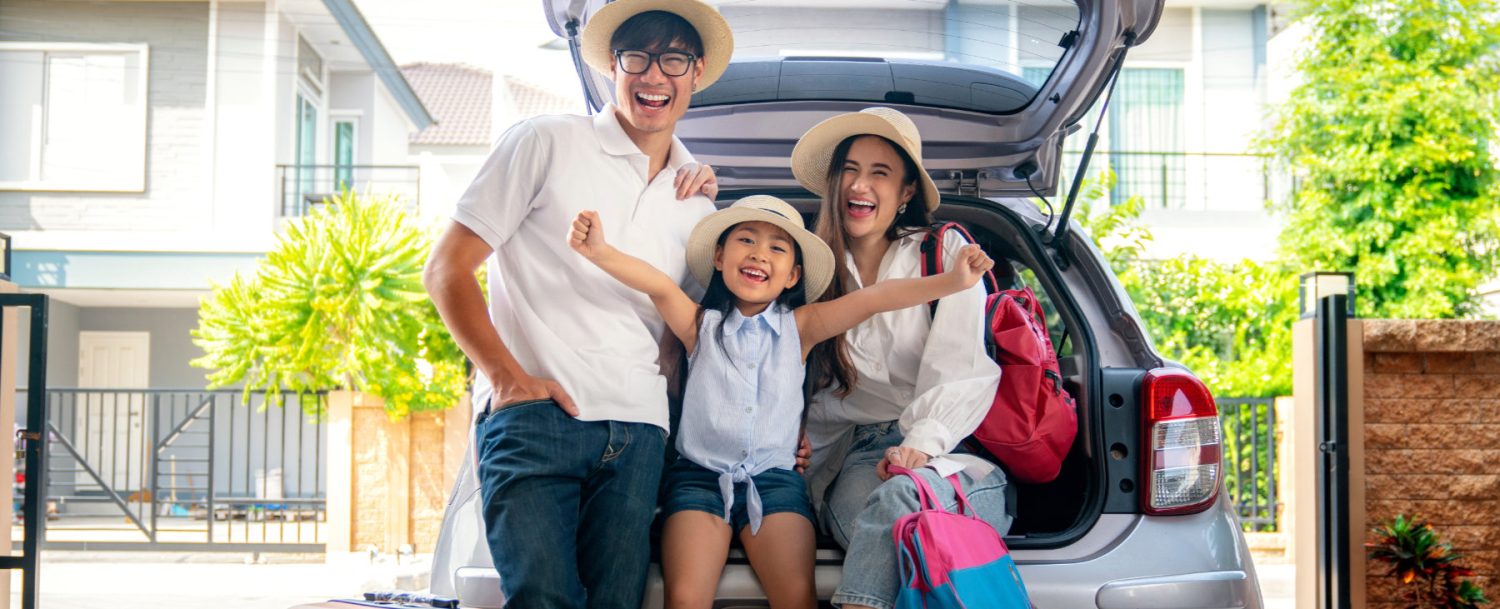 family next to car on first day of vacation