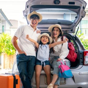 family next to car on first day of vacation