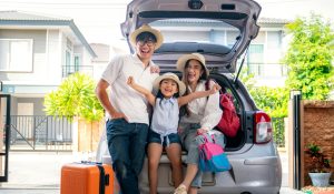 family next to car on first day of vacation
