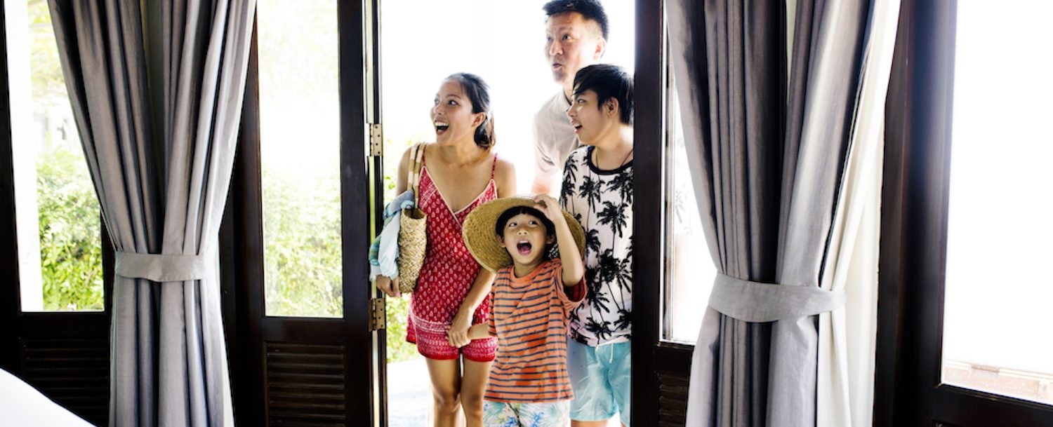 Asian family walking into bright vacation rental