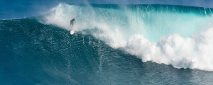 surfer riding big wave at jaws surf break