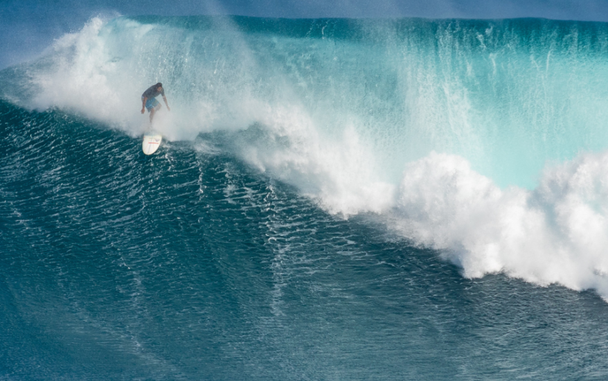 surfer riding big wave at jaws surf break