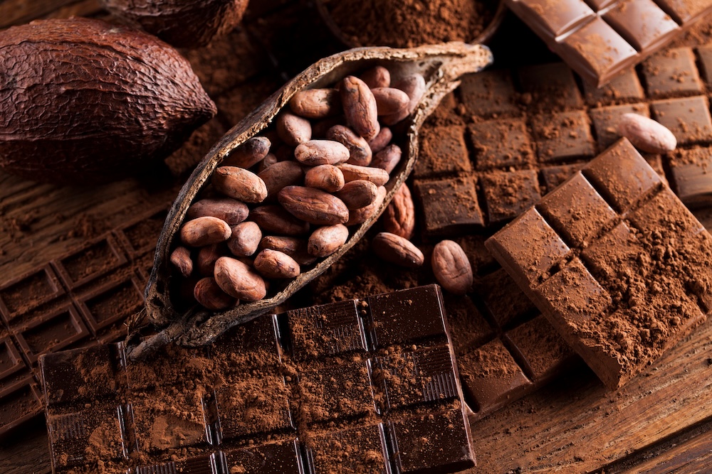 Dark homemade chocolate bars and cocoa pod on wooden